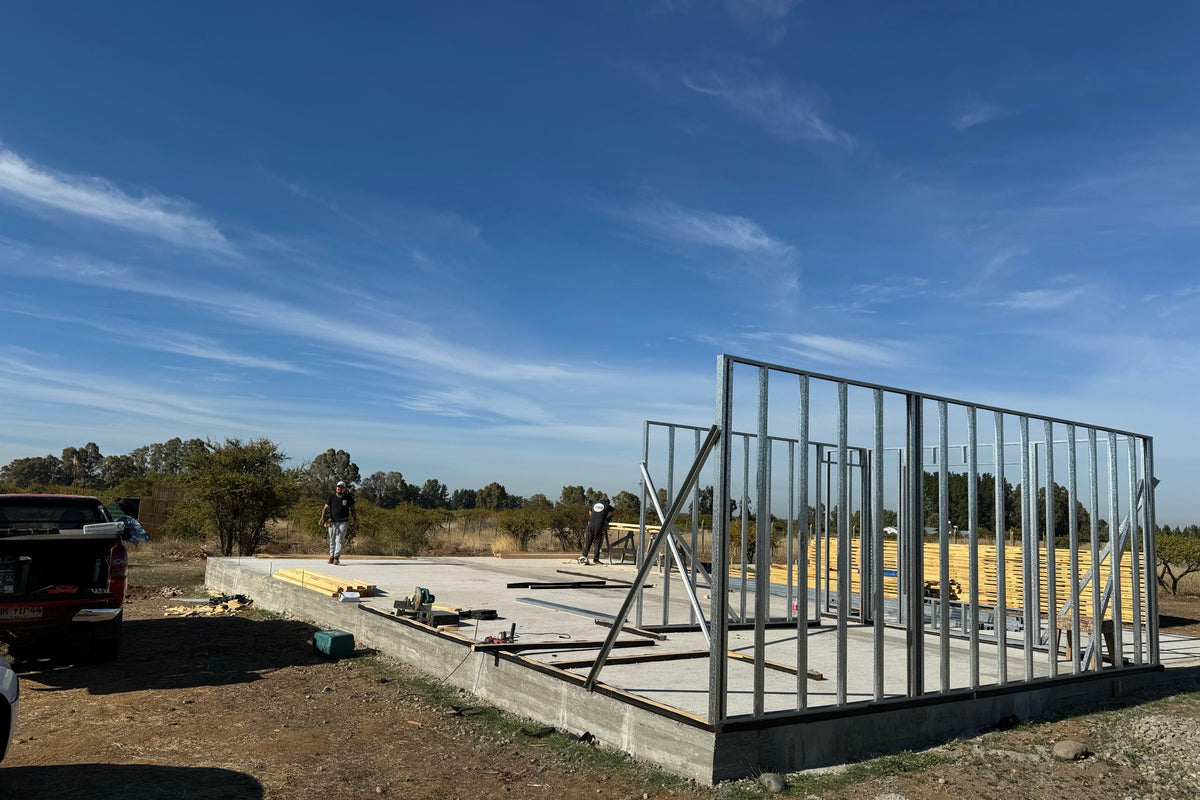 Radier de hormigón terminado y estructura metálica montada en una obra de CasasCAD