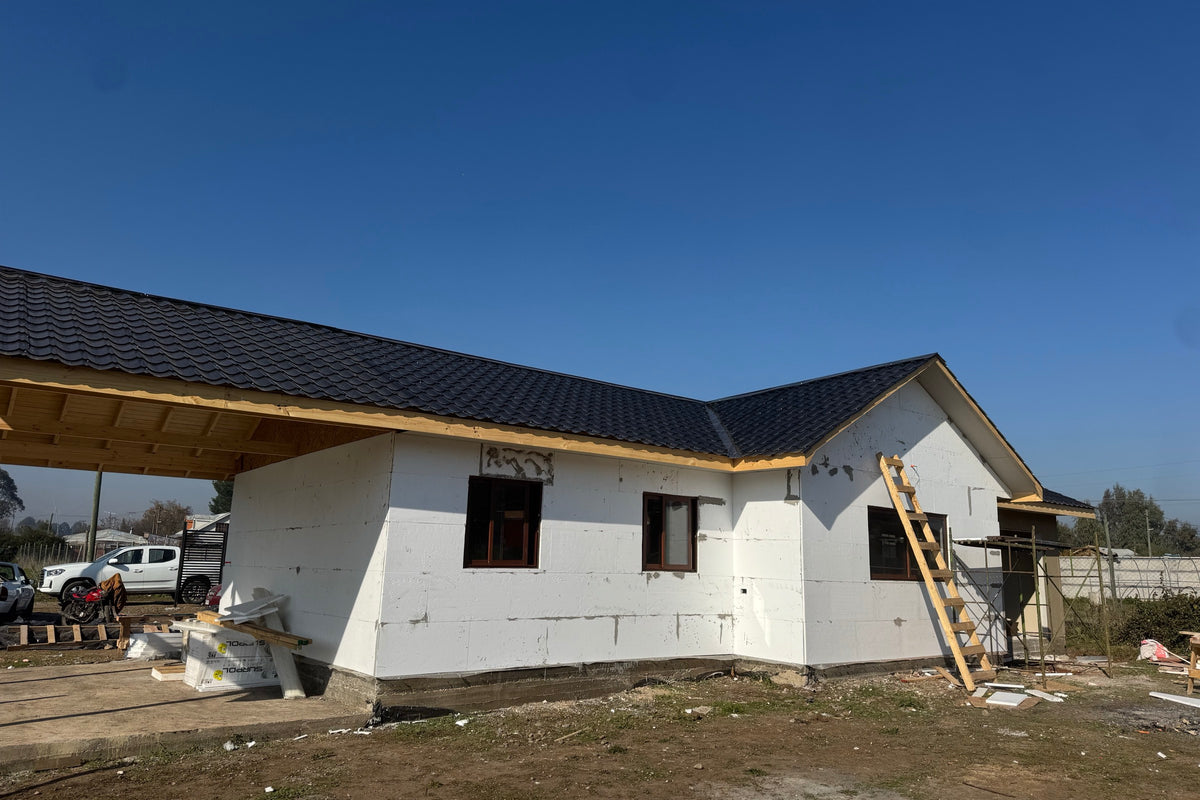 Casa en construcción de CasasCAD con muros de panel SIP montados y techumbre de zinc teja instalada