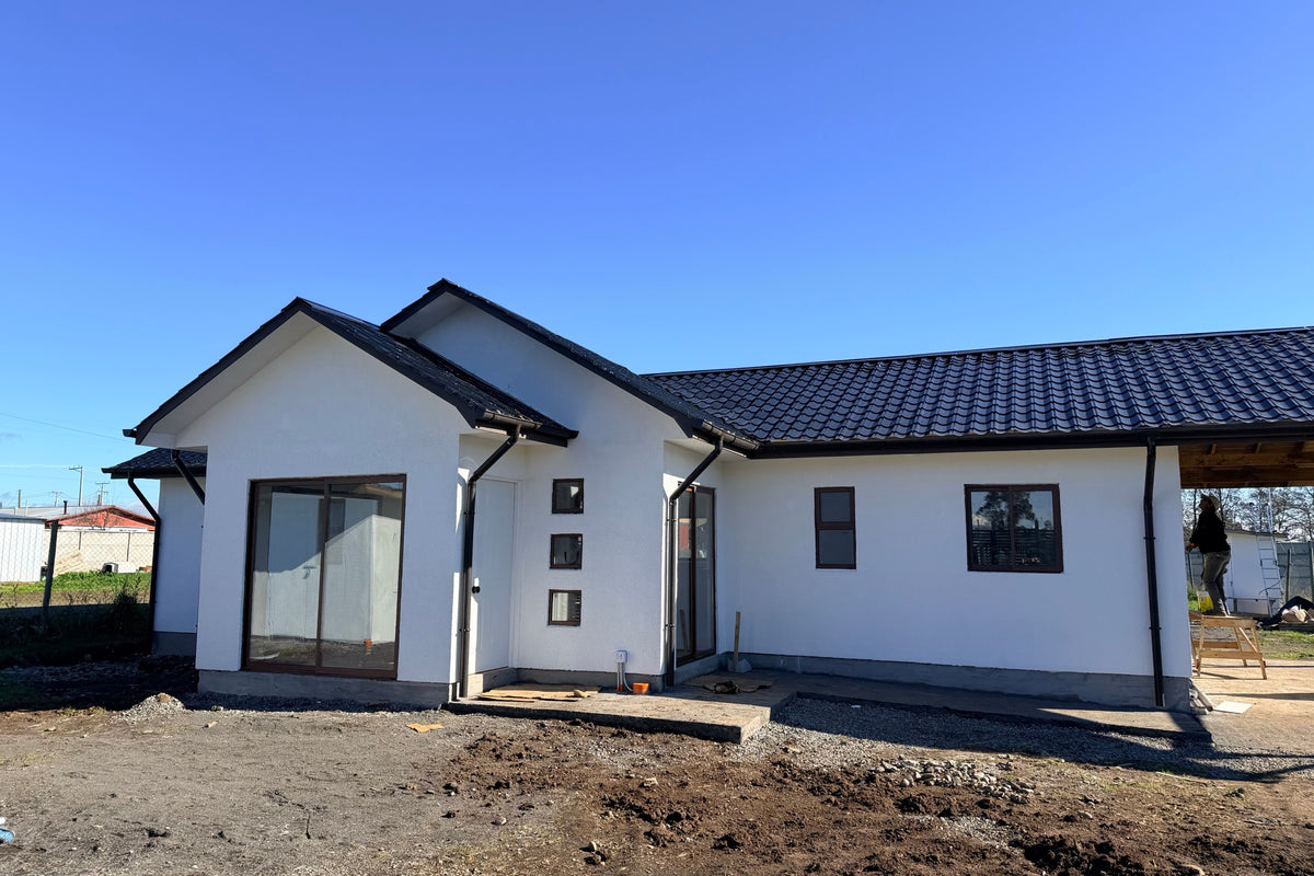 Casa CasasCAD en etapa de terminaciones, con fachada blanca y ventanas instaladas