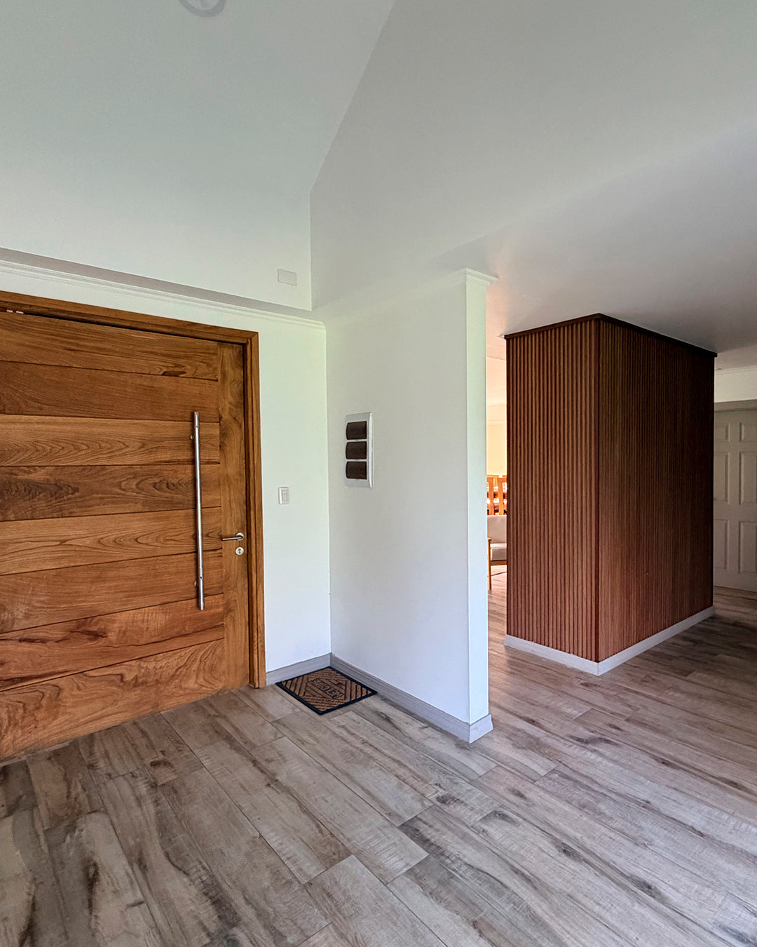 Hall de acceso terminado con puerta de madera