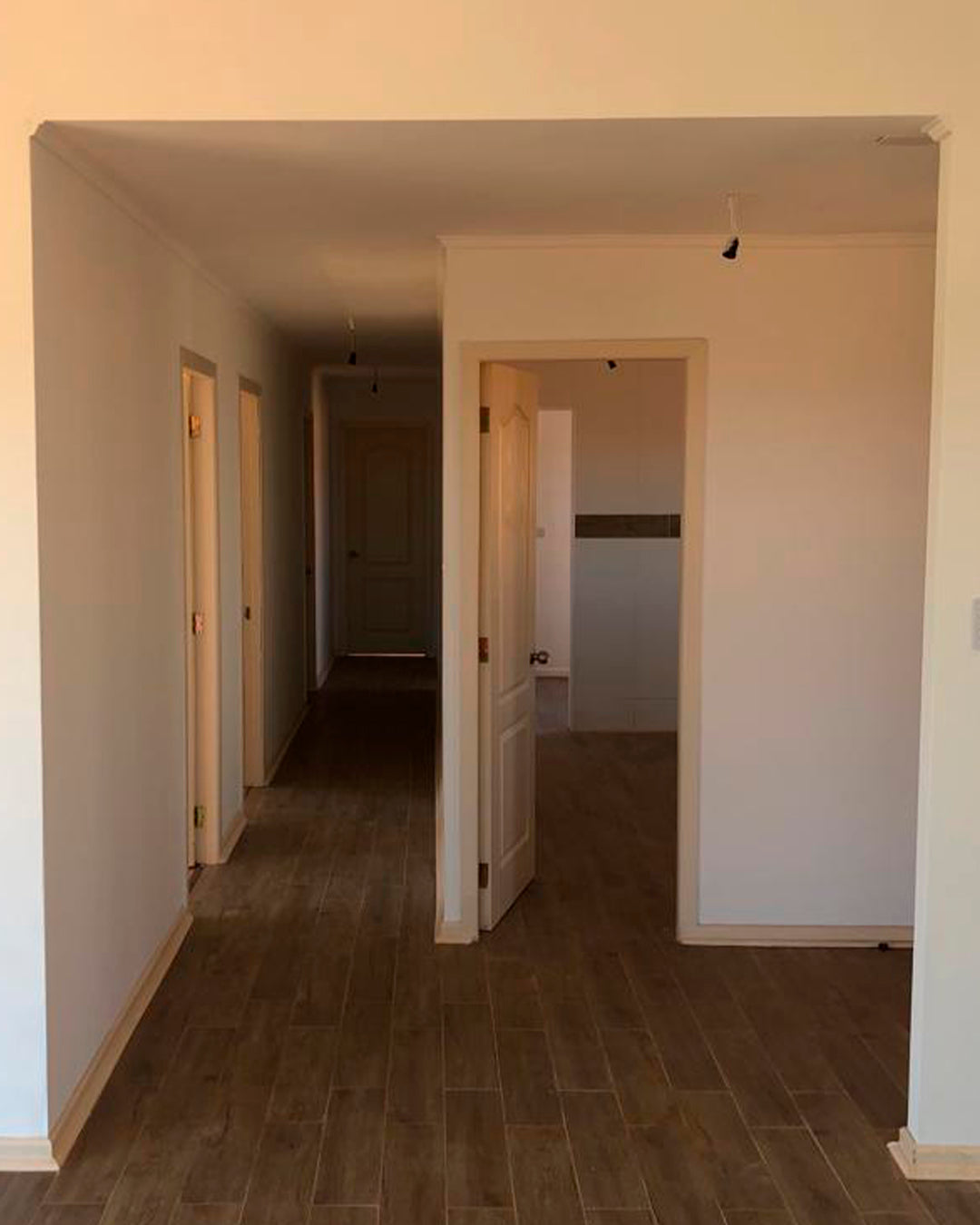 Pasillo interior terminado con piso tipo madera